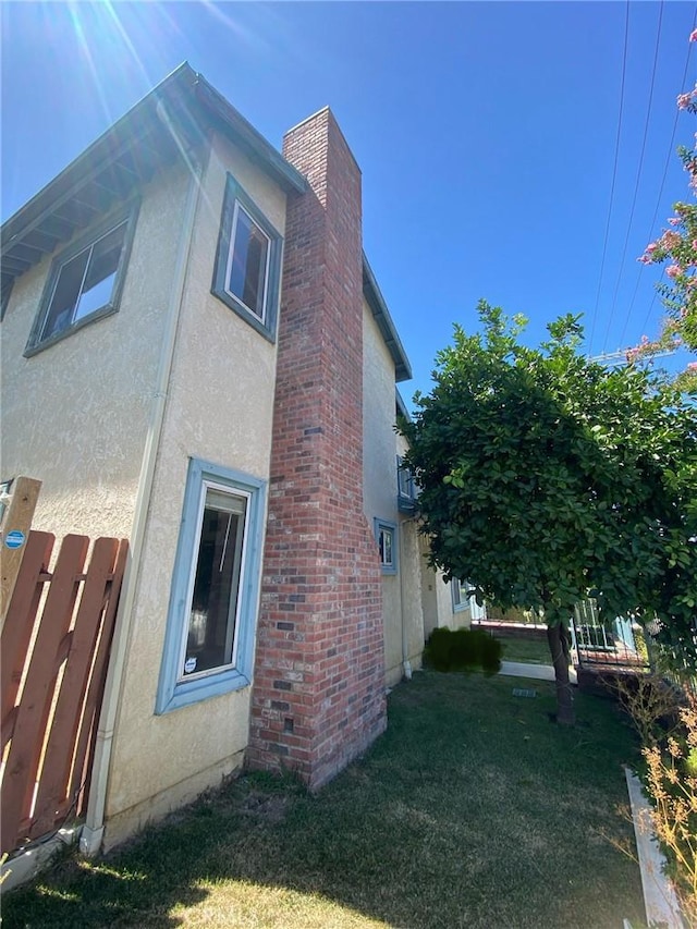 7527 Tampa Ave Unit 1, Reseda, CA 91335 - view of property exterior featuring stucco siding, a chimney, and a lawn