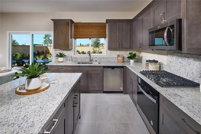 8176 Perada St, Jurupa Valley, CA 92509 - kitchen featuring appliances with stainless steel finishes, light tile patterned floors, dark brown cabinets, and light stone countertops