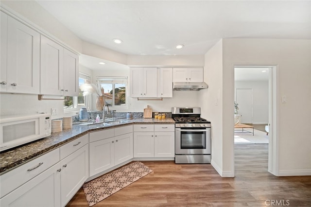 12218 Academy Way, Artesia, CA 90701 - kitchen with gas stove, under cabinet range hood, white microwave, white cabinetry, and recessed lighting