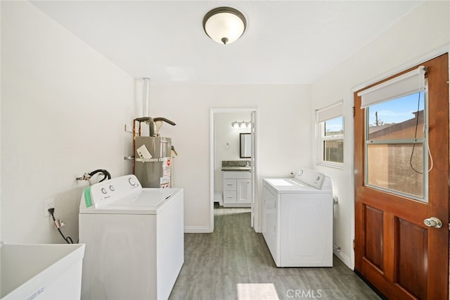 12218 Academy Way, Artesia, CA 90701 - laundry room featuring secured water heater, washing machine and clothes dryer, and light wood-type flooring