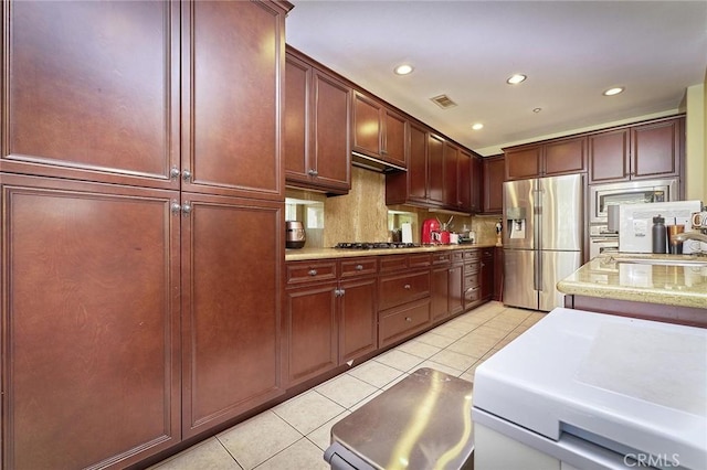 18977 Phelham Way, Yorba Linda, CA 92886 - kitchen featuring appliances with stainless steel finishes, light tile patterned flooring, tasteful backsplash, reddish brown cabinets, and recessed lighting