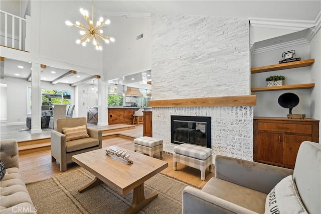 24901 Del Monte St, Laguna Hills, CA 92653 - living room featuring wood finished floors, ornate columns, a chandelier, a fireplace, and crown molding