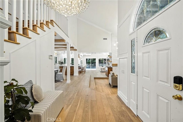 24901 Del Monte St, Laguna Hills, CA 92653 - foyer with a towering ceiling, light wood-style floors, a chandelier, stairs, and crown molding