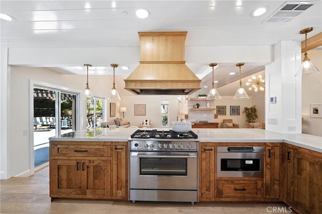 24901 Del Monte St, Laguna Hills, CA 92653 - kitchen with high end range, premium range hood, brown cabinets, light wood-style floors, and light countertops