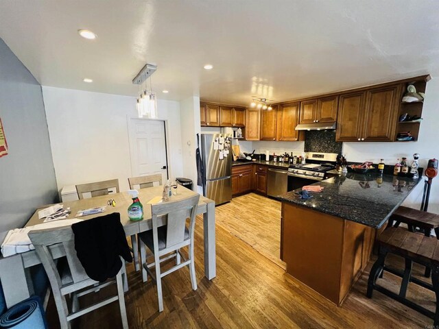 3943 Ingraham St, San Diego, CA 92109 - kitchen featuring stainless steel appliances, under cabinet range hood, a peninsula, light wood-style flooring, and open shelves