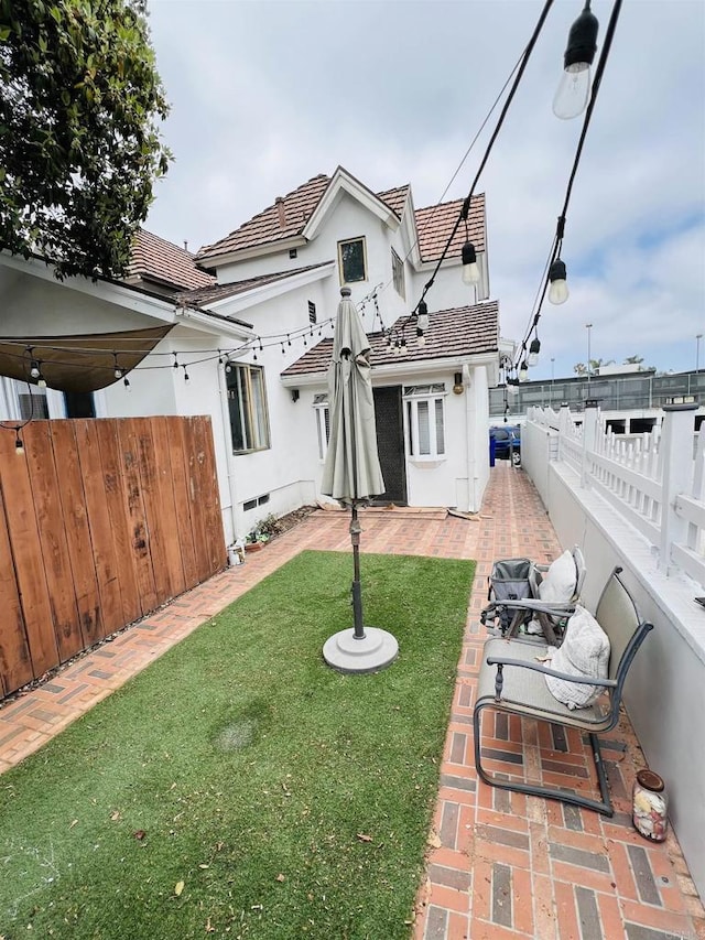 3943 Ingraham St, San Diego, CA 92109 - back of property with a fenced backyard, stucco siding, a tiled roof, and a patio