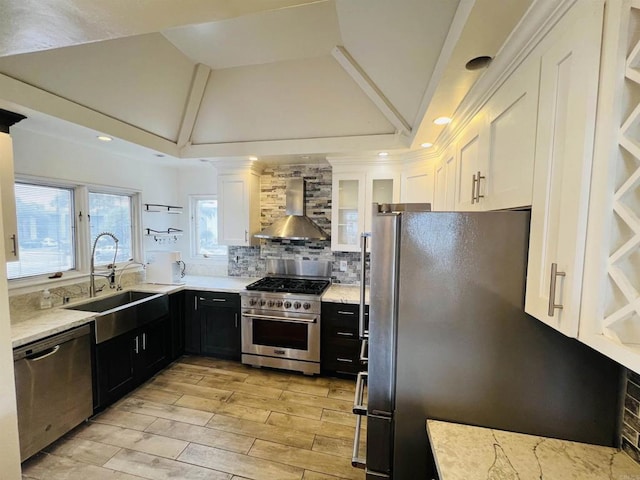 3943 Ingraham St, San Diego, CA 92109 - kitchen with wall chimney range hood, stainless steel appliances, white cabinets, lofted ceiling, and decorative backsplash