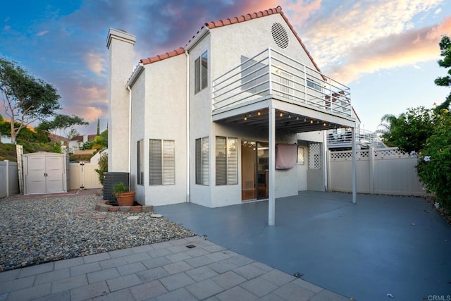 10500 Flora Azalea Ct, Santee, CA 92071 - back of property at dusk featuring a patio, stucco siding, a tile roof, and a balcony