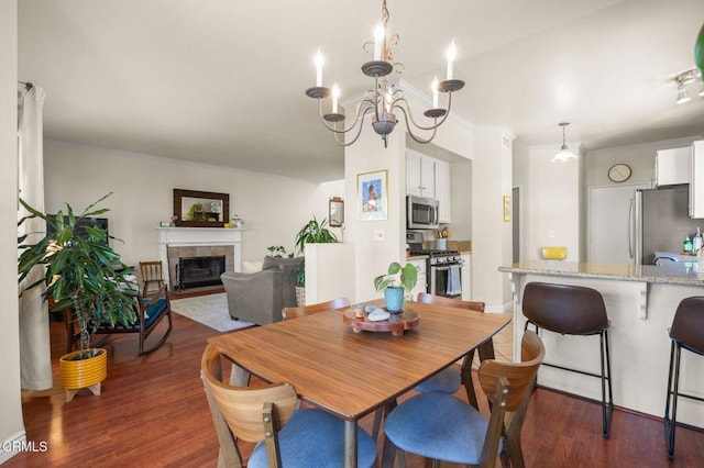 28802 Raintree Ln, Saugus, CA 91390 - dining space with wood finished floors, a fireplace, a chandelier, and crown molding