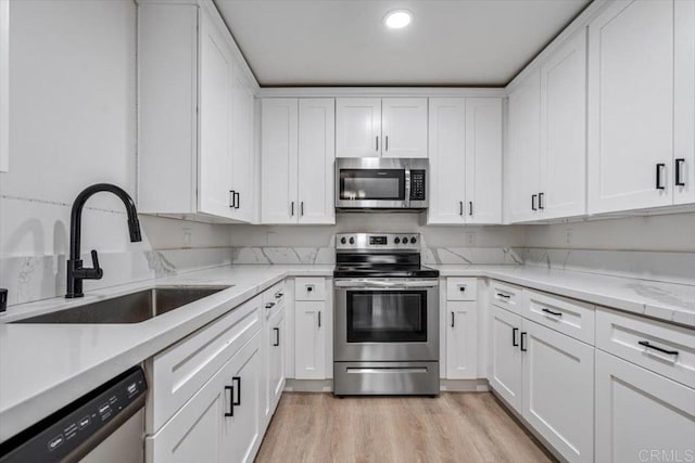 10784 N Magnolia Dr Unit H8, Santee, CA 92071 - kitchen featuring stainless steel appliances, white cabinetry, light wood-type flooring, recessed lighting, and light stone countertops