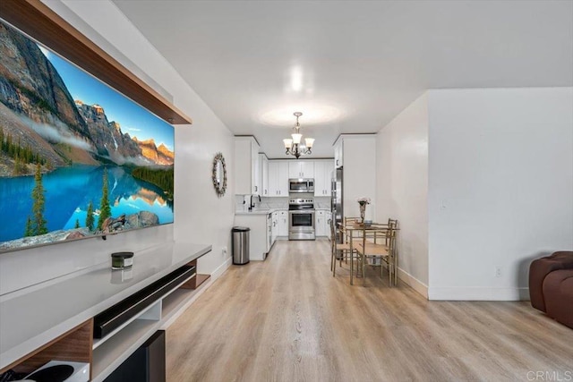 10784 N Magnolia Dr Unit H8, Santee, CA 92071 - kitchen with stainless steel appliances, a chandelier, light wood finished floors, light countertops, and white cabinetry
