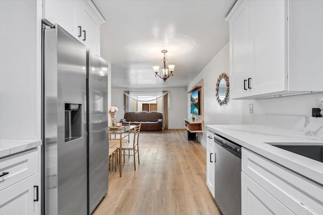 10784 N Magnolia Dr Unit H8, Santee, CA 92071 - kitchen with appliances with stainless steel finishes, a chandelier, white cabinetry, light wood-style floors, and light stone counters