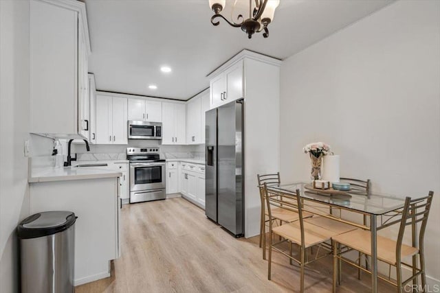 10784 N Magnolia Dr Unit H8, Santee, CA 92071 - kitchen featuring stainless steel appliances, light countertops, a chandelier, light wood finished floors, and white cabinetry