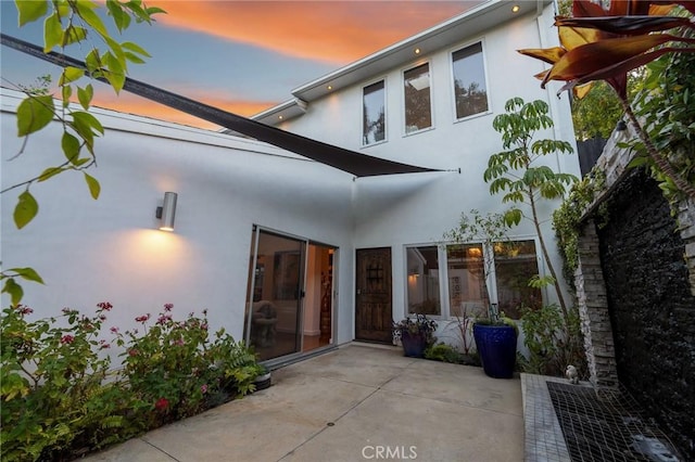 2531 N Commonwealth Ave, Los Angeles, CA 90027 - back of house at dusk featuring stucco siding and a patio area