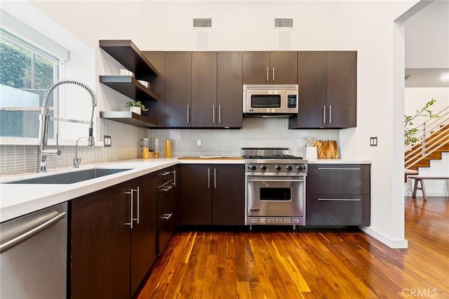 2531 N Commonwealth Ave, Los Angeles, CA 90027 - kitchen with stainless steel appliances, dark wood finished floors, light countertops, and tasteful backsplash