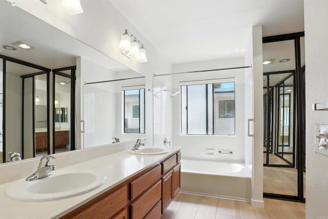 8373 Suntree Pl, San Diego, CA 92119 - bathroom featuring healthy amount of natural light, a garden tub, double vanity, and wood finished floors