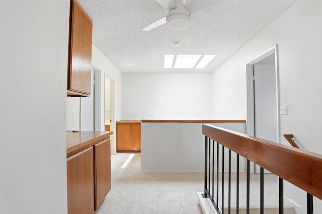 8373 Suntree Pl, San Diego, CA 92119 - hall featuring an upstairs landing, a textured ceiling, light carpet, and a skylight