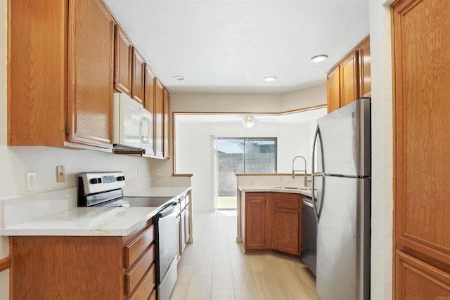 8373 Suntree Pl, San Diego, CA 92119 - kitchen with appliances with stainless steel finishes, brown cabinets, a ceiling fan, light wood-style floors, and recessed lighting