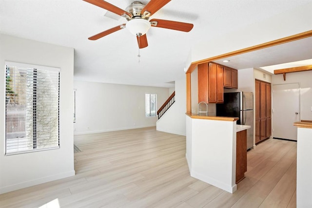 8373 Suntree Pl, San Diego, CA 92119 - kitchen with freestanding refrigerator, light wood-type flooring, brown cabinets, ceiling fan, and light countertops