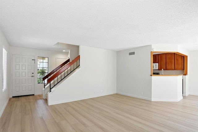8373 Suntree Pl, San Diego, CA 92119 - foyer with a textured ceiling, light wood-style floors, and stairway