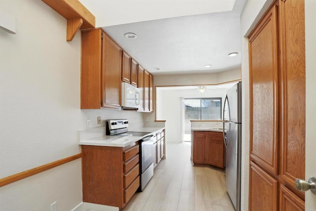 8373 Suntree Pl, San Diego, CA 92119 - kitchen with appliances with stainless steel finishes, brown cabinets, light countertops, light wood-style flooring, and recessed lighting