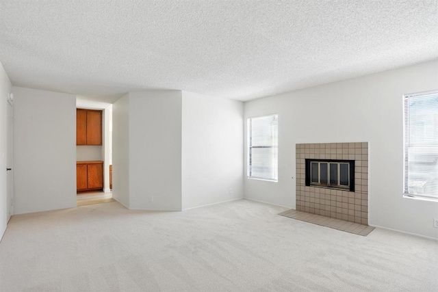 8373 Suntree Pl, San Diego, CA 92119 - unfurnished living room featuring a tiled fireplace, plenty of natural light, a textured ceiling, and light carpet