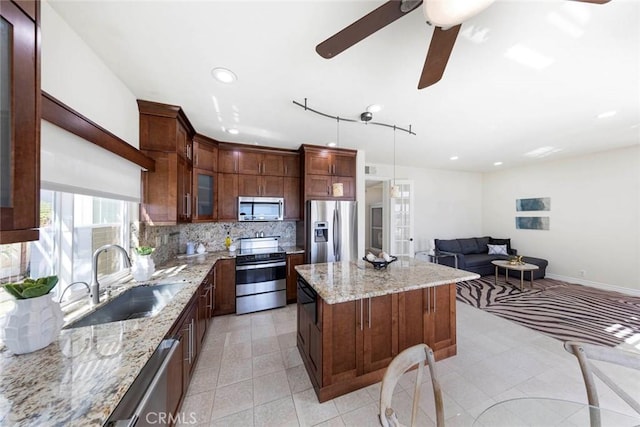 4 Narbonne, Laguna Niguel, CA 92677 - kitchen featuring appliances with stainless steel finishes, a center island, recessed lighting, backsplash, and light stone countertops
