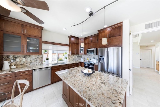 4 Narbonne, Laguna Niguel, CA 92677 - kitchen featuring stainless steel appliances, tasteful backsplash, a center island, glass insert cabinets, and a ceiling fan