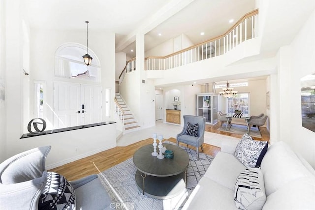 4 Narbonne, Laguna Niguel, CA 92677 - living room featuring stairway, wood finished floors, a chandelier, a towering ceiling, and recessed lighting