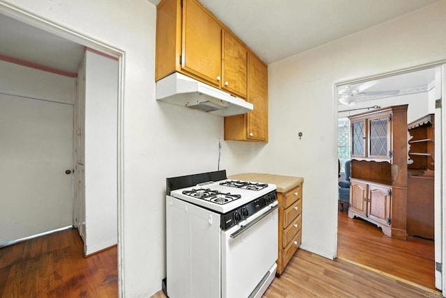 1465 S 43rd St, San Diego, CA 92113 - kitchen featuring white gas stove, under cabinet range hood, light wood-style flooring, brown cabinetry, and light countertops