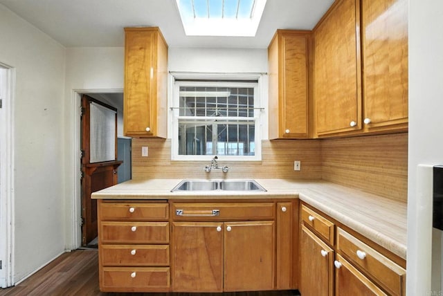 1465 S 43rd St, San Diego, CA 92113 - kitchen featuring dark wood-type flooring, backsplash, a skylight, light countertops, and brown cabinetry