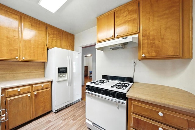 1465 S 43rd St, San Diego, CA 92113 - kitchen with white appliances, under cabinet range hood, light countertops, light wood finished floors, and brown cabinets