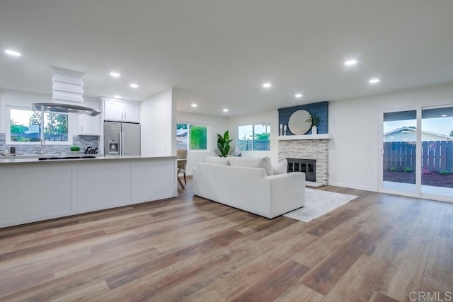 6947 Wallsey Dr, San Diego, CA 92119 - living room featuring light wood-type flooring, recessed lighting, and a stone fireplace