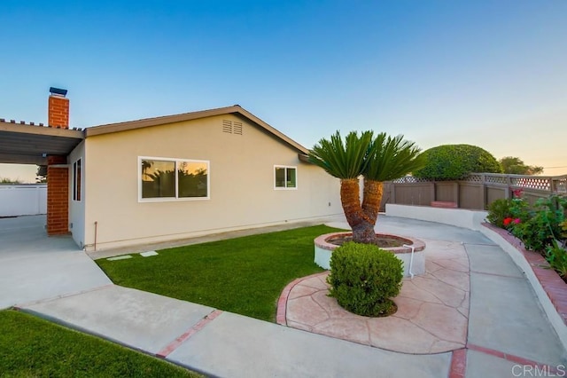 6947 Wallsey Dr, San Diego, CA 92119 - property exterior at dusk with stucco siding, a patio area, and a chimney