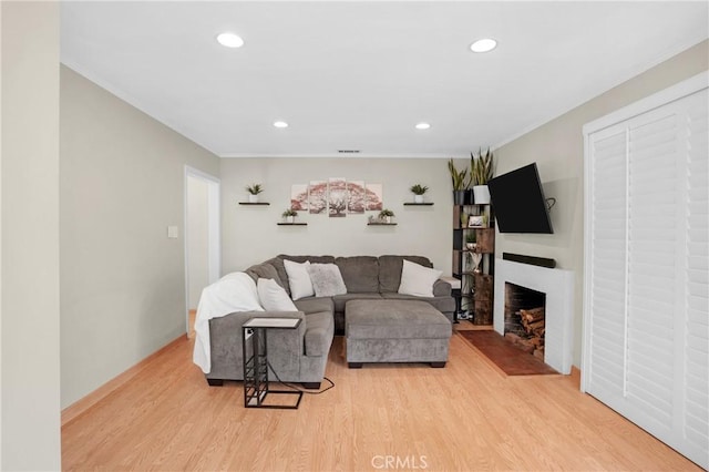 16918 Baltar St, Van Nuys, CA 91406 - living area featuring light wood finished floors, ornamental molding, a fireplace with flush hearth, and recessed lighting