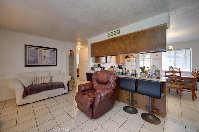 2130 Ocean St, Oceano, CA 93445 - living room with a textured ceiling, light tile patterned floors, a chandelier, and a heating unit