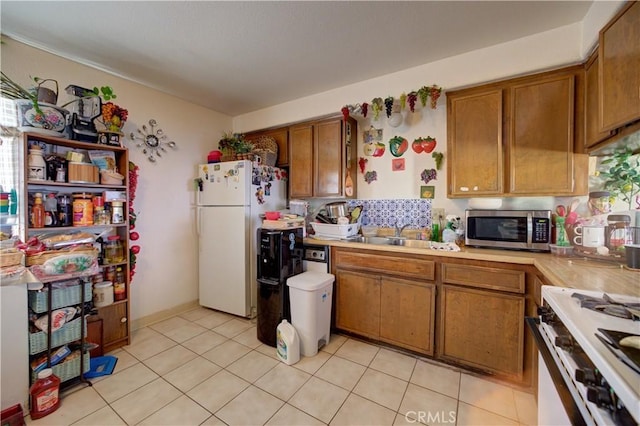 2130 Ocean St, Oceano, CA 93445 - kitchen with white appliances, brown cabinets, light countertops, and light tile patterned flooring