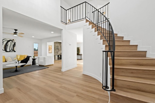2858 Lehigh Ct, Oceanside, CA 92056 - staircase featuring wood finished floors, ceiling fan, a premium fireplace, a high ceiling, and recessed lighting