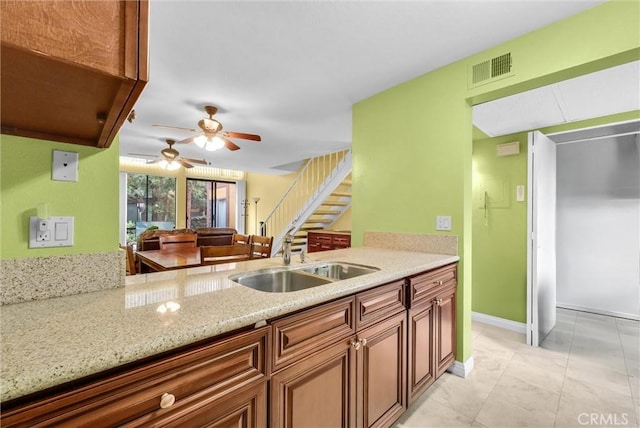 10642 Shoreline Dr Unit 80, Norwalk, CA 90650 - kitchen with a ceiling fan, light stone countertops, brown cabinetry, and light tile patterned floors