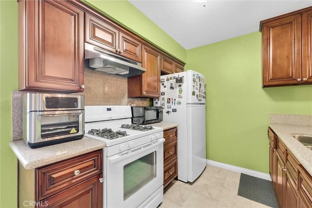 10642 Shoreline Dr Unit 80, Norwalk, CA 90650 - kitchen with white appliances, under cabinet range hood, decorative backsplash, and brown cabinets