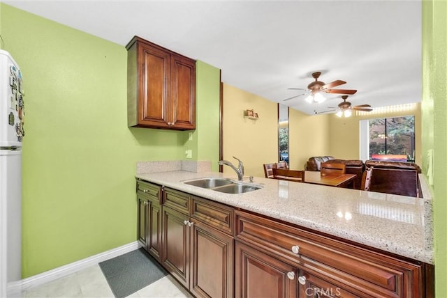10642 Shoreline Dr Unit 80, Norwalk, CA 90650 - kitchen with a ceiling fan, light stone countertops, and a peninsula