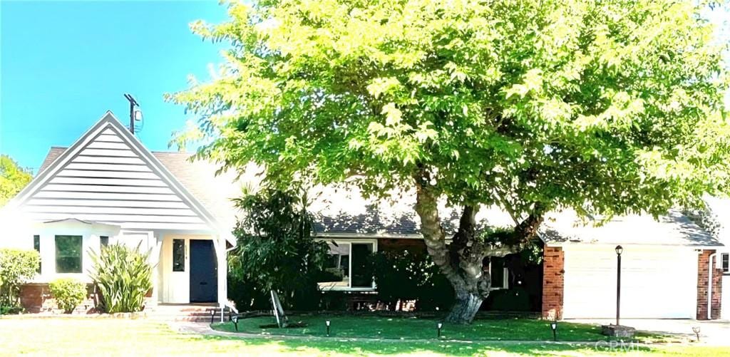 6818 Chisholm Ave, Van Nuys, CA 91406 - view of front of house featuring a front yard, an attached garage, and driveway