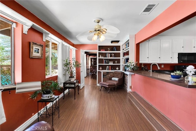 19955 Chickasaw Rd, Apple Valley, CA 92307 - kitchen featuring black microwave, dark countertops, ceiling fan, white cabinets, and dark wood finished floors
