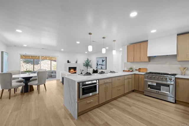 1654 Yale St, Chula Vista, CA 91913 - kitchen with appliances with stainless steel finishes, a peninsula, light wood-type flooring, a premium fireplace, and premium range hood