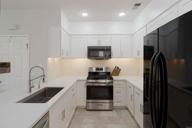 1148 Valdivia Ct, Chula Vista, CA 91910 - kitchen with black refrigerator with ice dispenser, stainless steel range with gas stovetop, white cabinetry, light countertops, and light tile patterned floors
