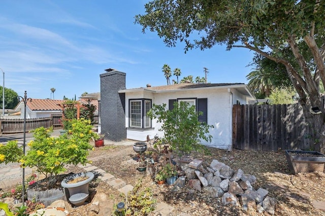 1220 Palomar Ter, Escondido, CA 92027 - back of property with stucco siding, a fenced backyard, and a chimney
