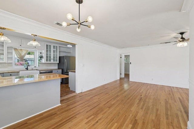 1220 Palomar Ter, Escondido, CA 92027 - kitchen featuring stainless steel appliances, a chandelier, light wood finished floors, crown molding, and glass insert cabinets