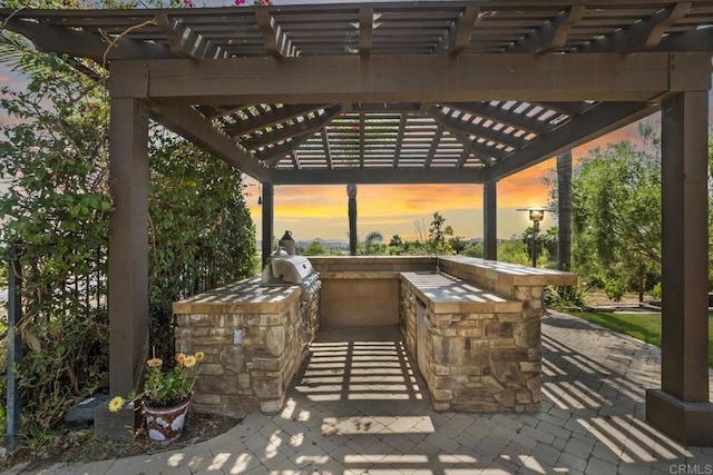 14786 Cool Valley Ranch Rd, Valley Center, CA 92082 - patio terrace at dusk featuring a pergola, an outdoor kitchen, and a patio