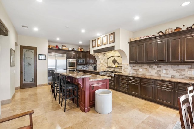 14786 Cool Valley Ranch Rd, Valley Center, CA 92082 - kitchen with built in appliances, a breakfast bar area, tasteful backsplash, light stone countertops, and recessed lighting