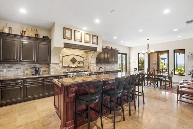 14786 Cool Valley Ranch Rd, Valley Center, CA 92082 - kitchen with a kitchen bar, decorative backsplash, stone countertops, stove, and recessed lighting